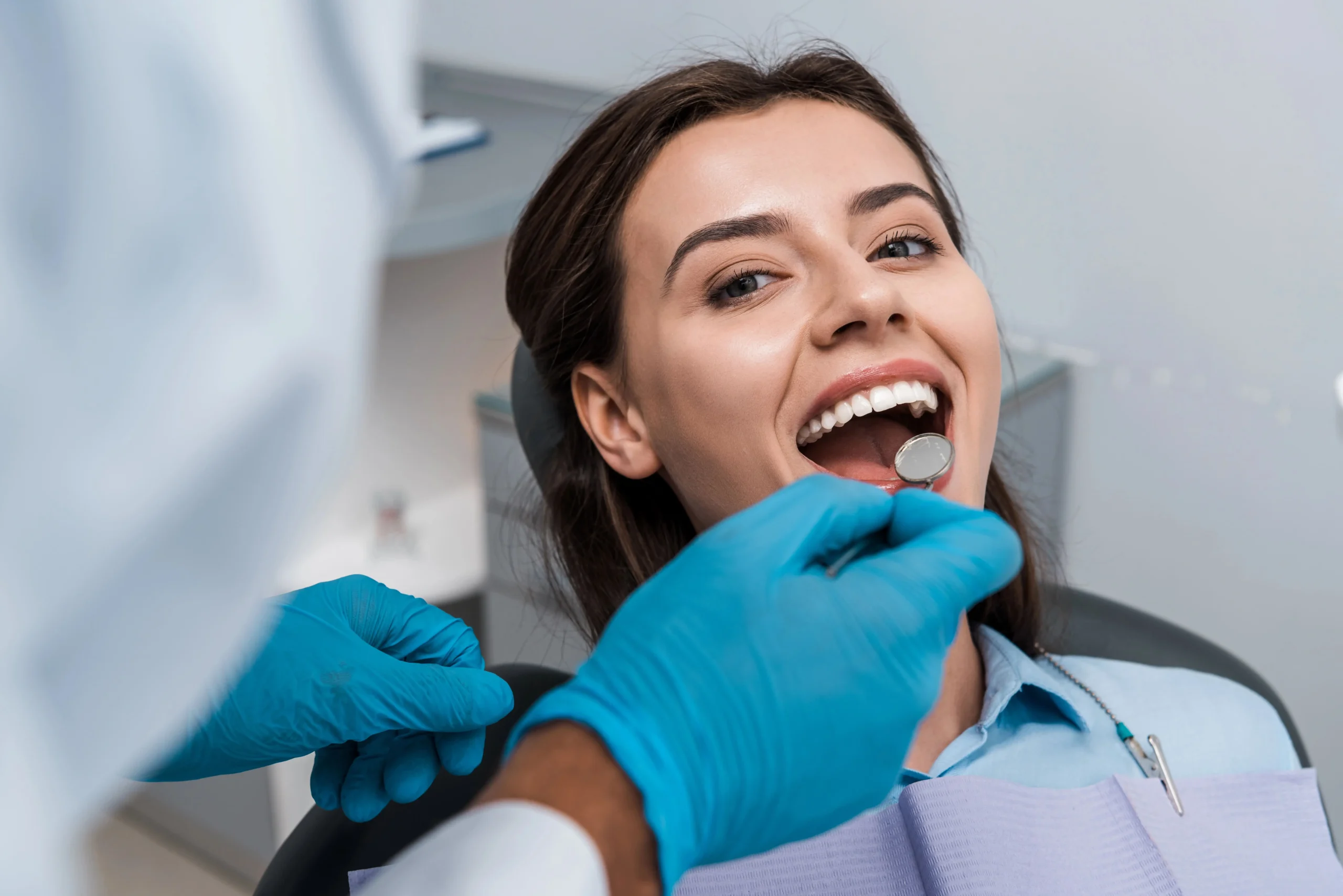 A young woman at the dentist getting her teeth checked and cleaned.