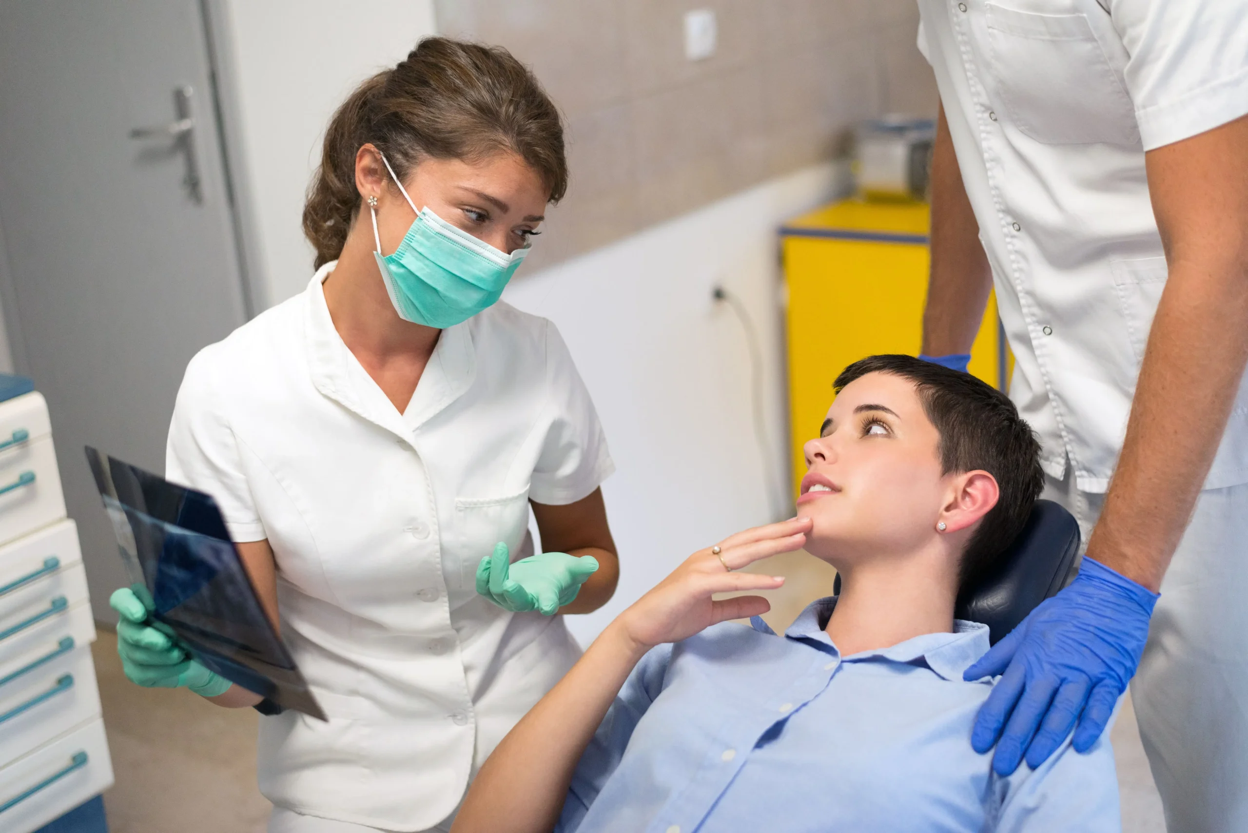 Woman in dental chair while a dentist describes a procedure to her.