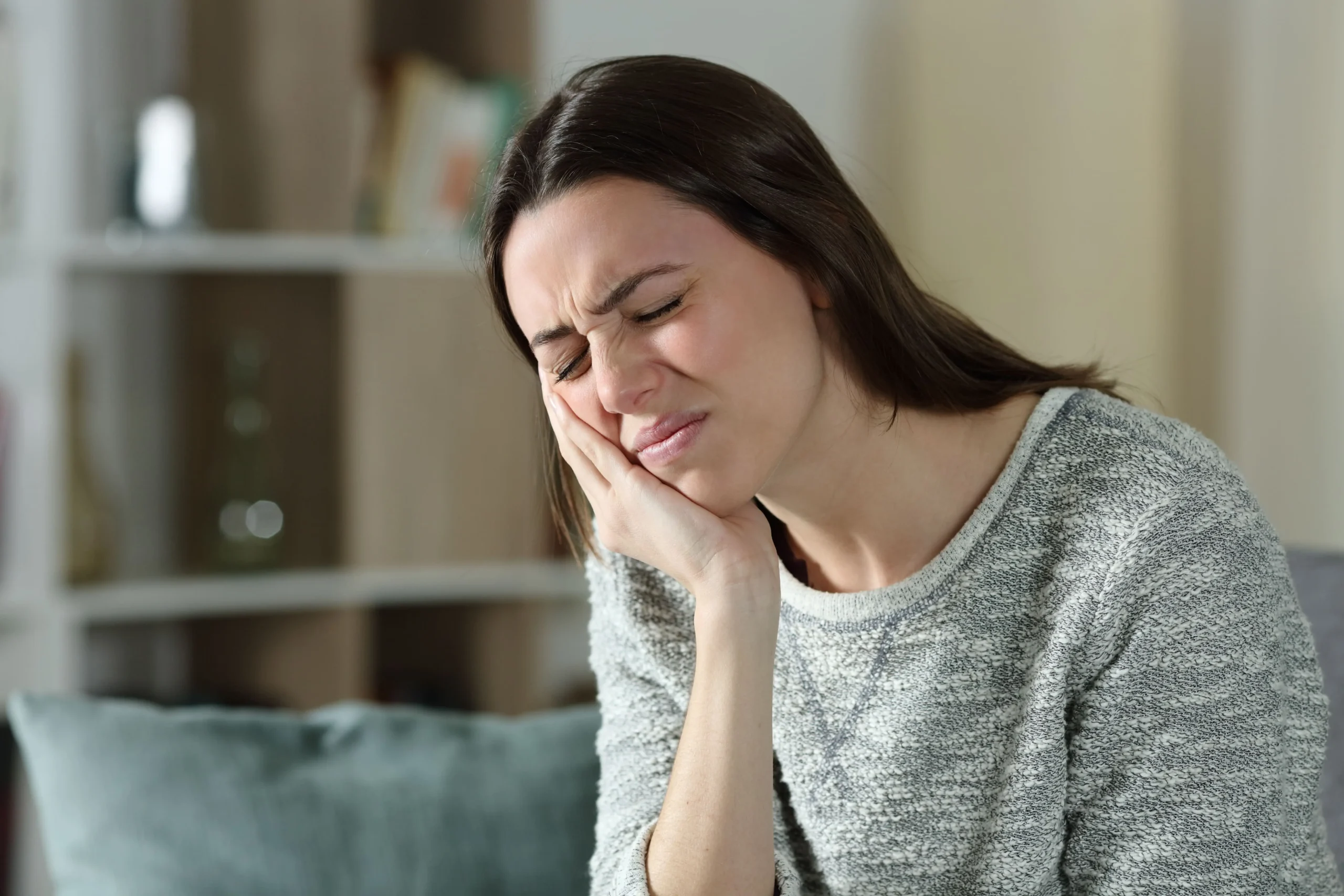 Woman with jaw pain holding her face
